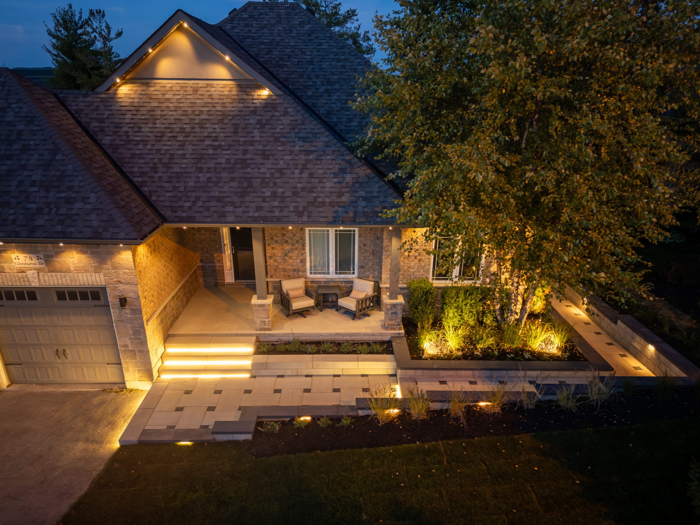 Illuminated house entrance with night landscaping