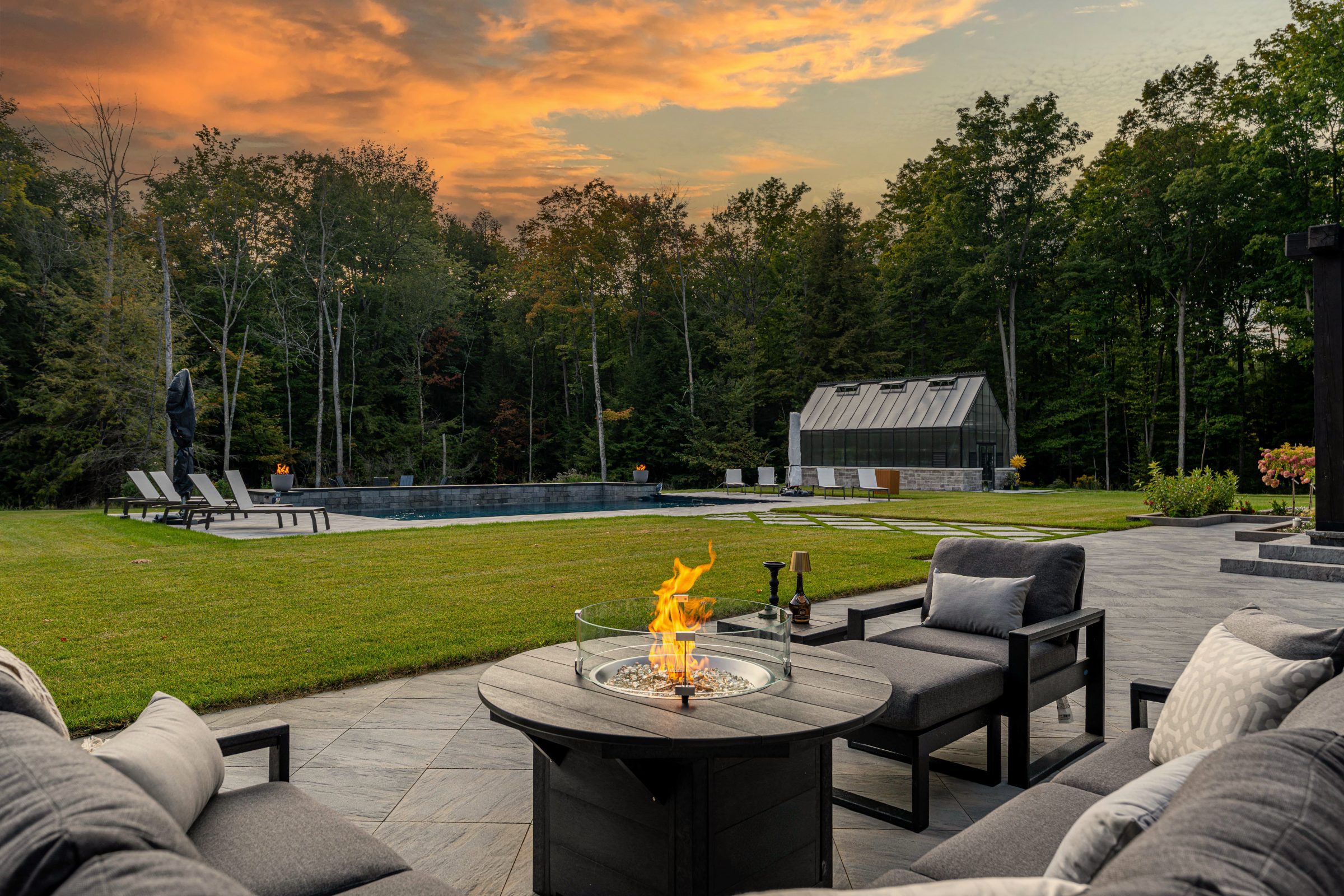 Luxury patio with pool and sunset view.