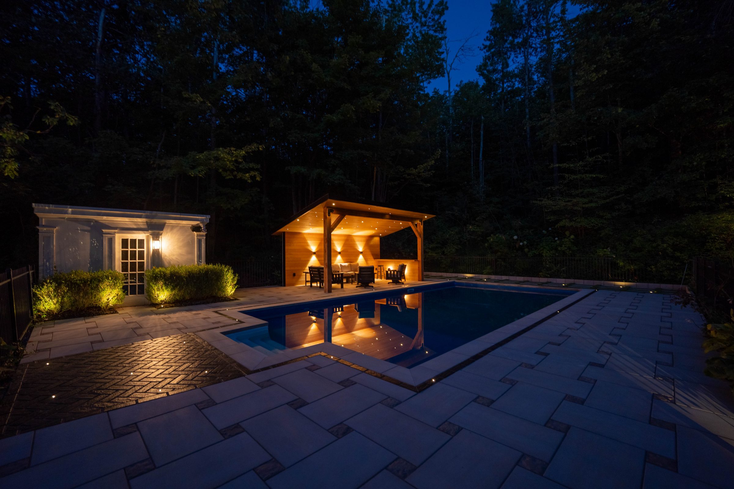 Illuminated patio and pool at night