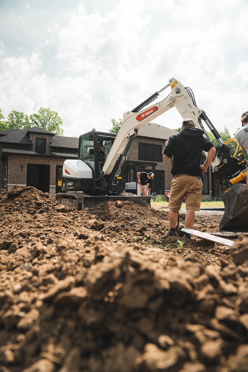 Construction workers with excavator at building site