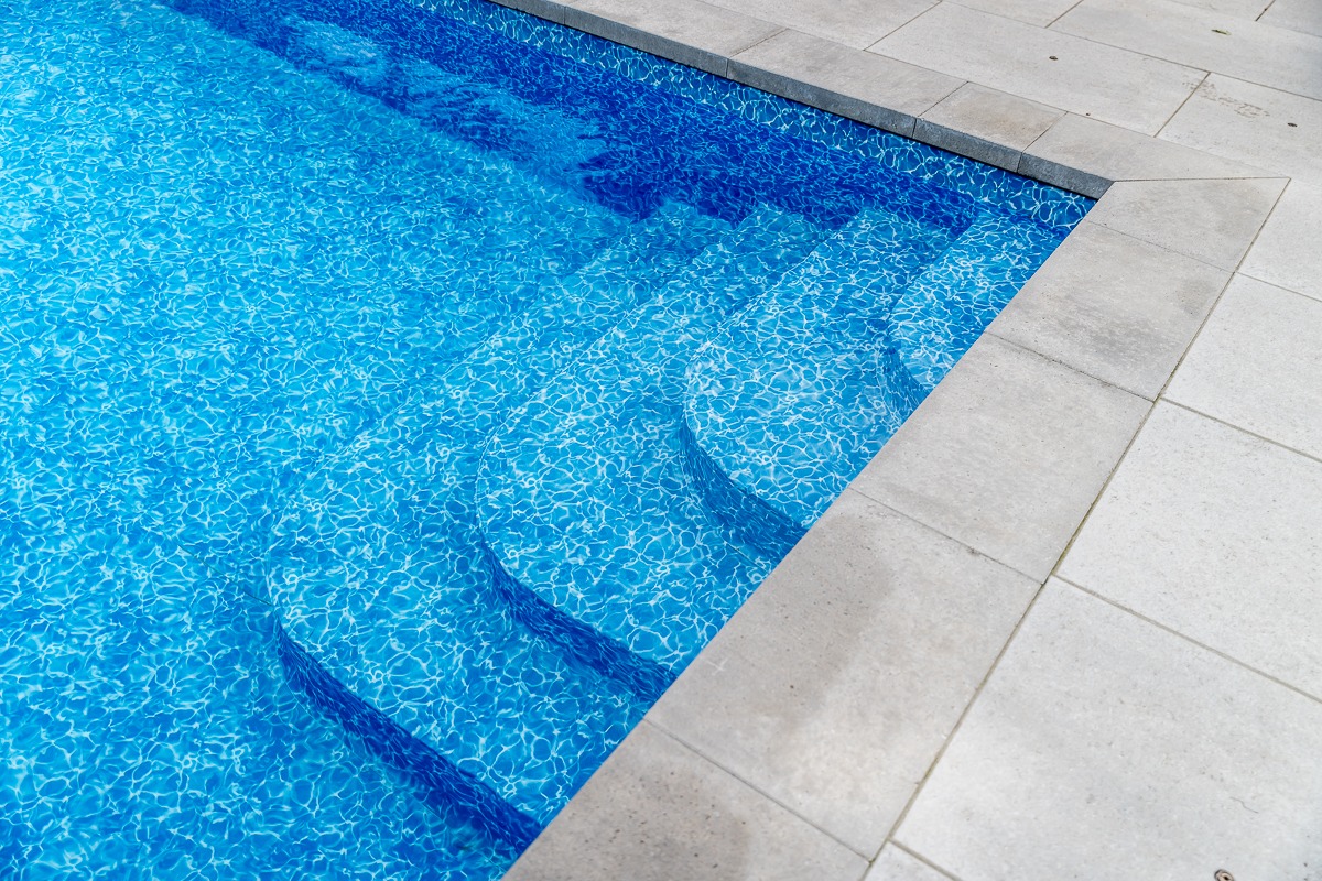 Clean blue swimming pool with steps