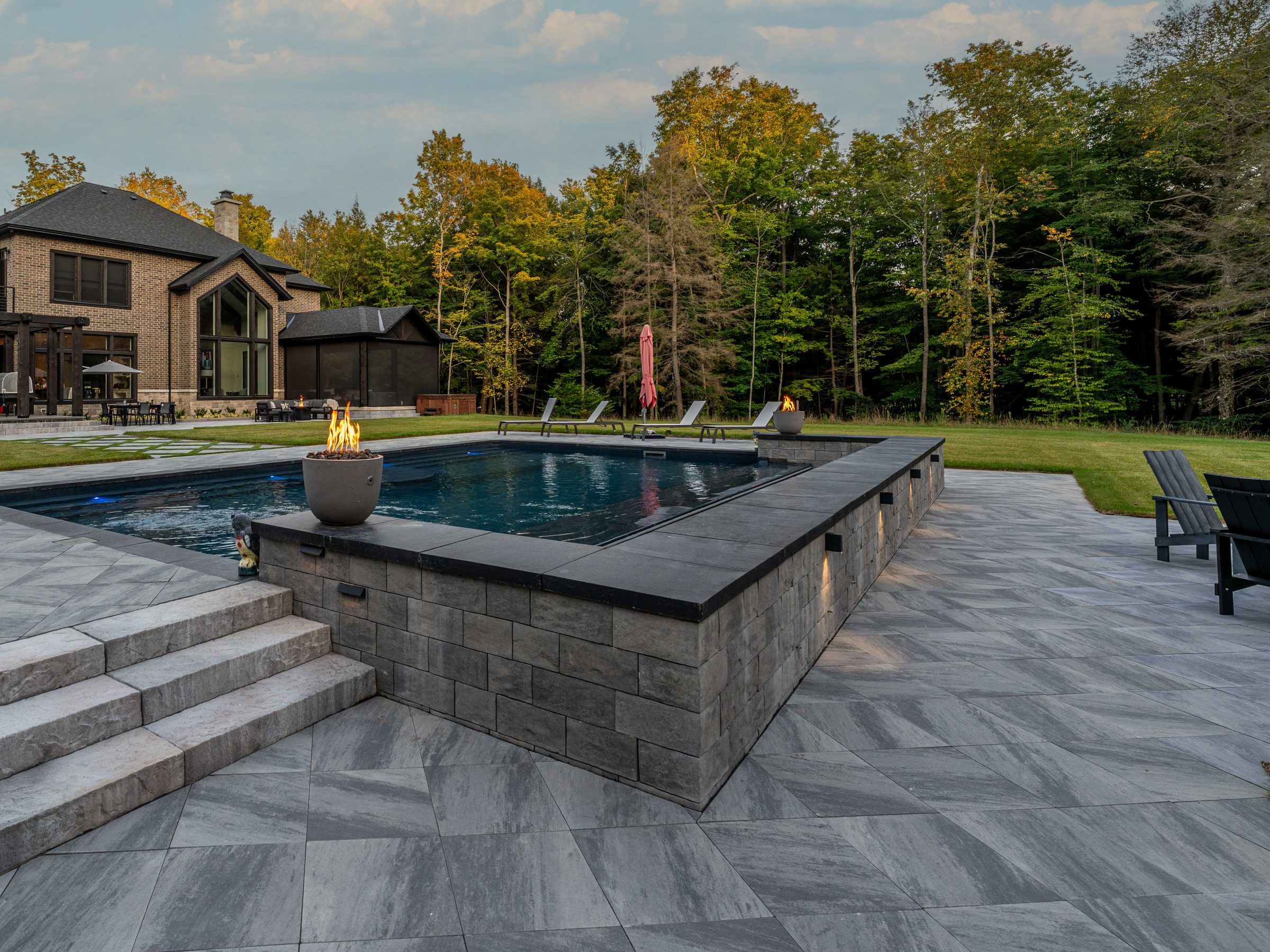 Luxury backyard with pool, fire features, and patio.