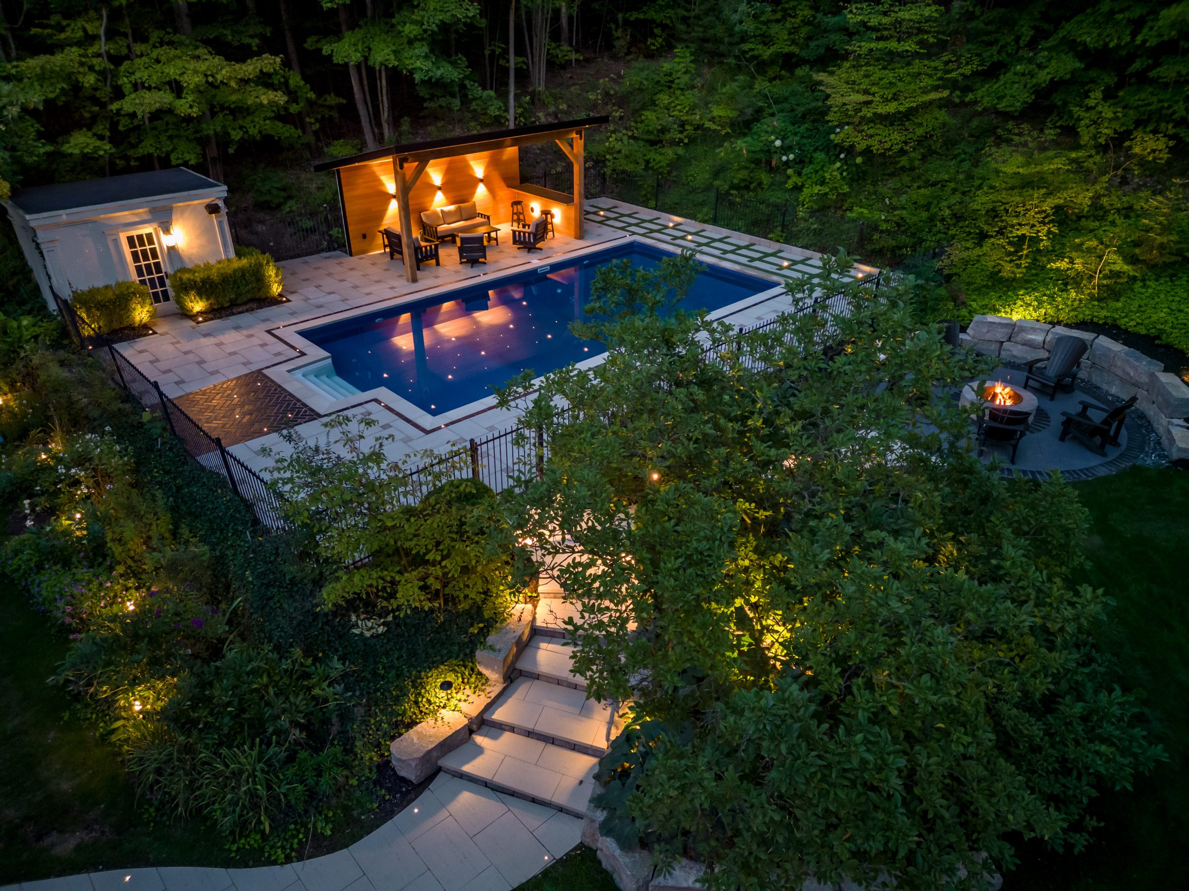 Luxurious backyard with pool, patio, and fire pit