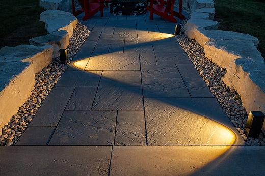 Pathway illuminated by outdoor lights at dusk.