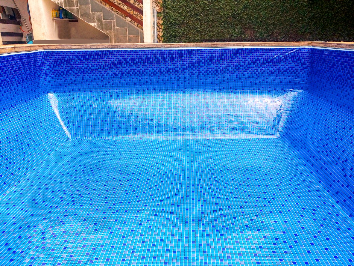 Empty swimming pool with blue mosaic tiles.