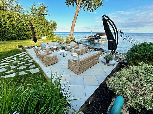 Lakeside patio with furniture and umbrellas