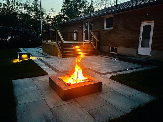 Backyard patio fire pit at dusk.