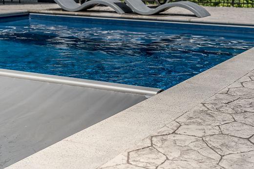 Modern swimming pool with stone tile decking.