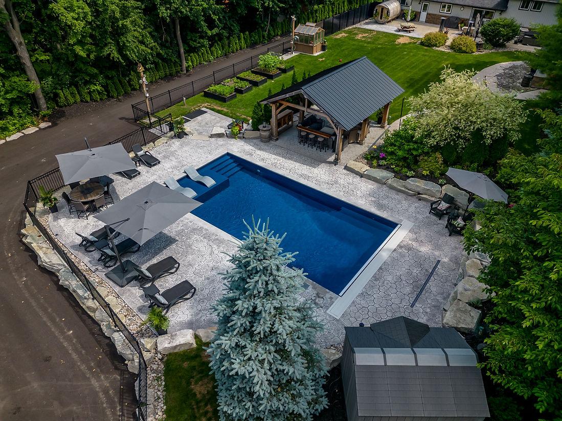 Aerial view of a backyard pool with seating.