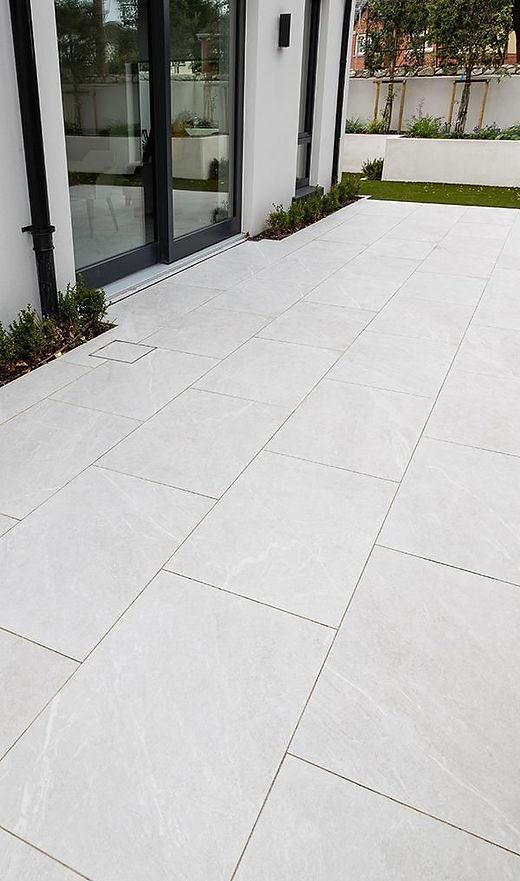 Modern patio with large white tiles.