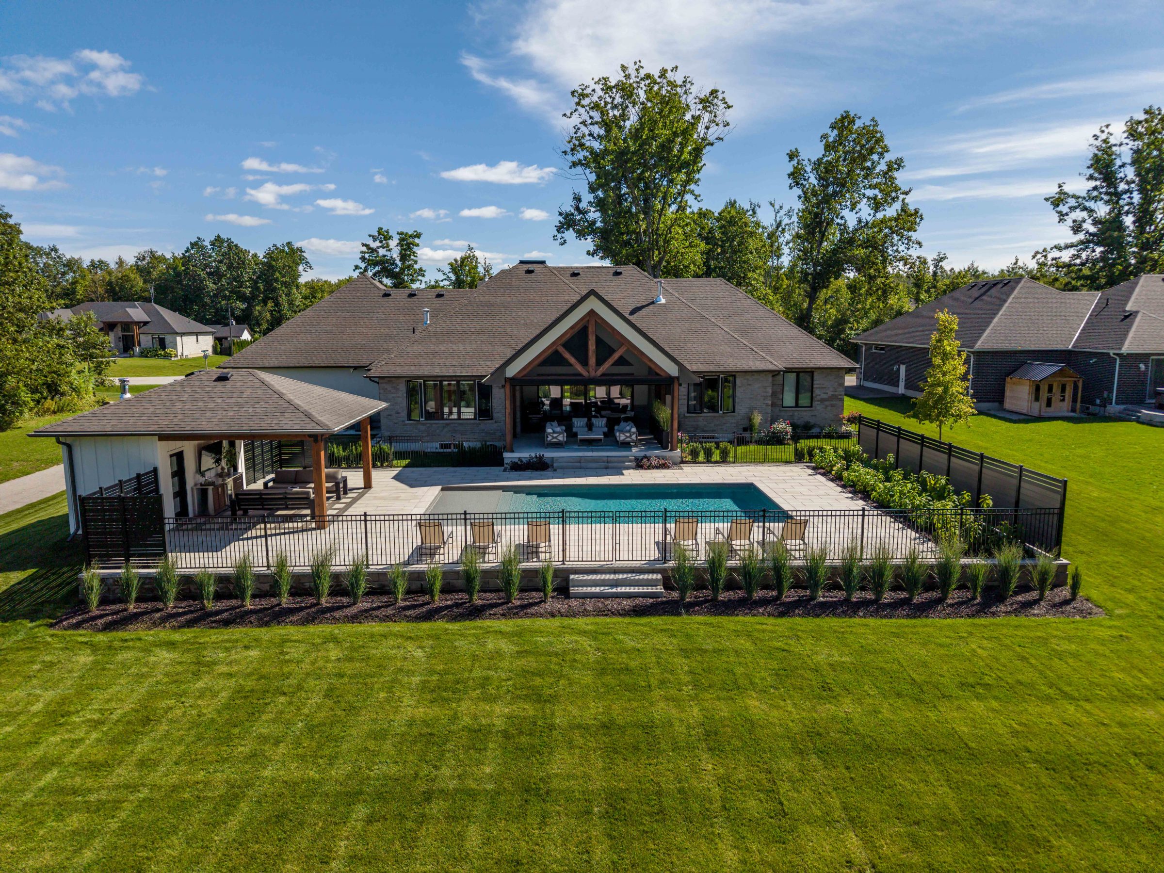Modern house with backyard pool and patio.